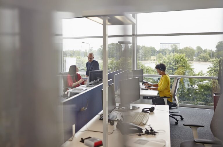woman-with-headset-working-in-open-plan-office